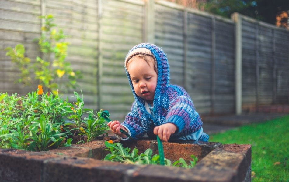 enfant dans le jardin clôturé