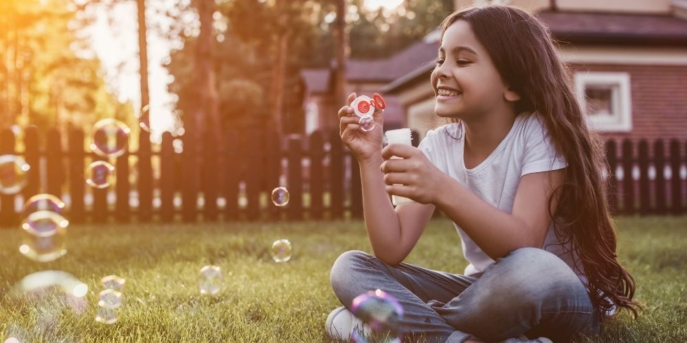 petite fille qui joue dans le jardin avec clôture