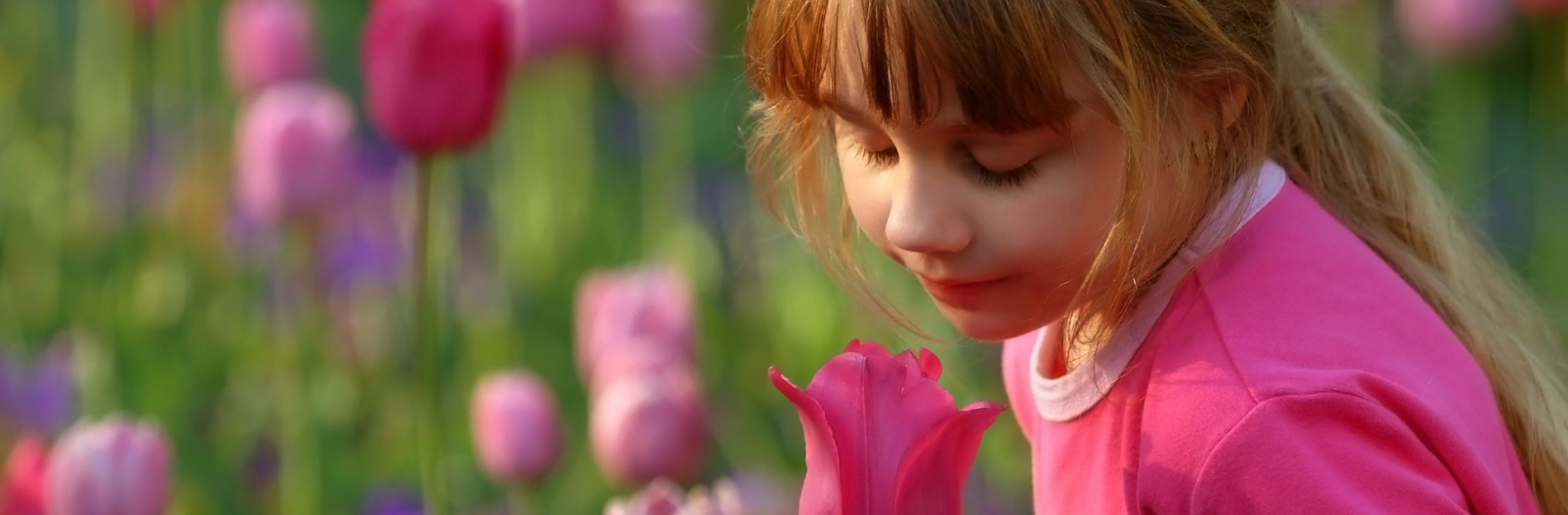 Une petite fille qui sent une fleur
